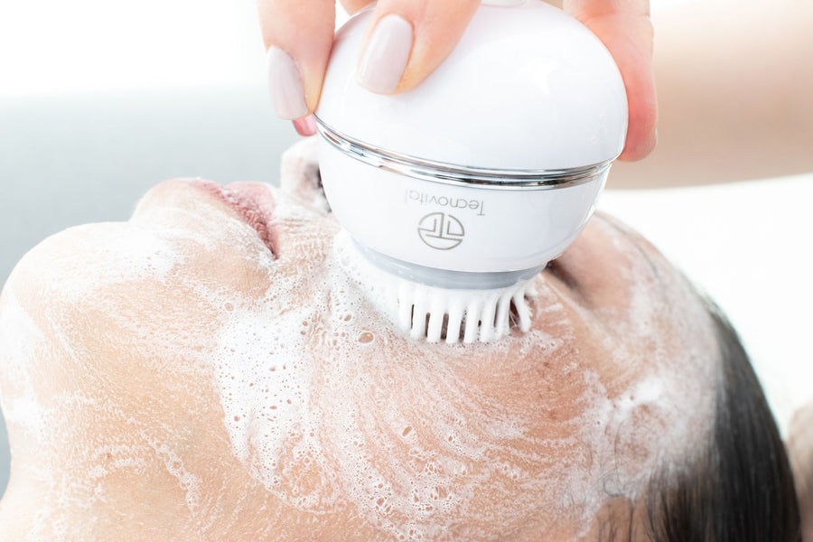 Nettoyage du visage avec une brosse électrique et de la mousse