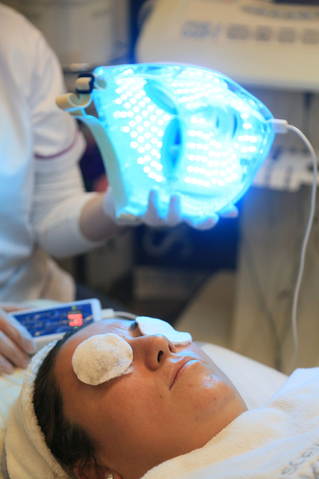 Femme utilisant un masque LED visage de luminothérapie à la maison